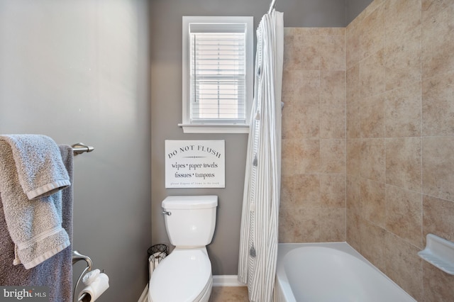 full bath featuring toilet, baseboards, and shower / bathtub combination with curtain
