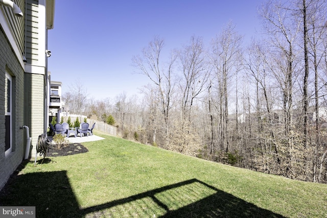 view of green lawn featuring a patio area