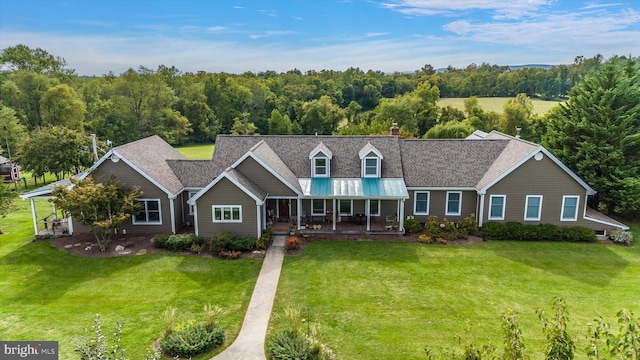 view of front facade featuring a porch, a front lawn, a chimney, and a shingled roof