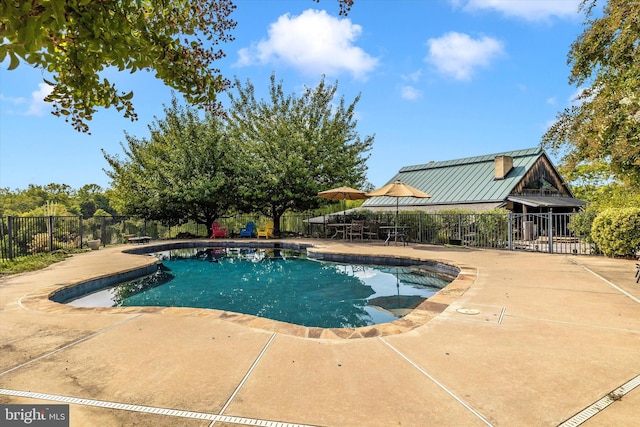 view of pool with a patio area and fence