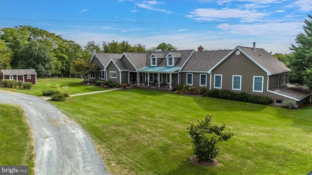 view of front of property with a front lawn, a chimney, covered porch, and dirt driveway