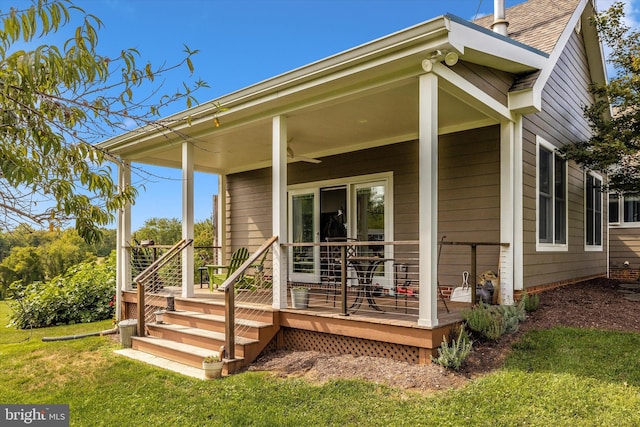 rear view of property featuring a yard, ceiling fan, and a deck