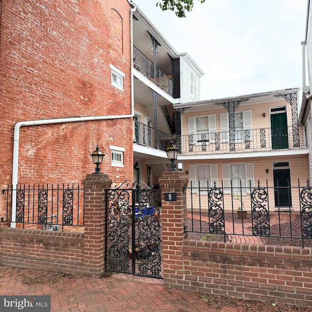 view of front of home with a fenced front yard and brick siding