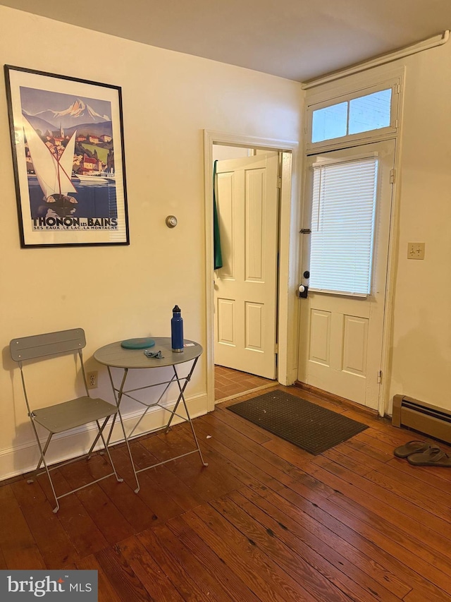 entryway with a baseboard radiator, hardwood / wood-style floors, and baseboards