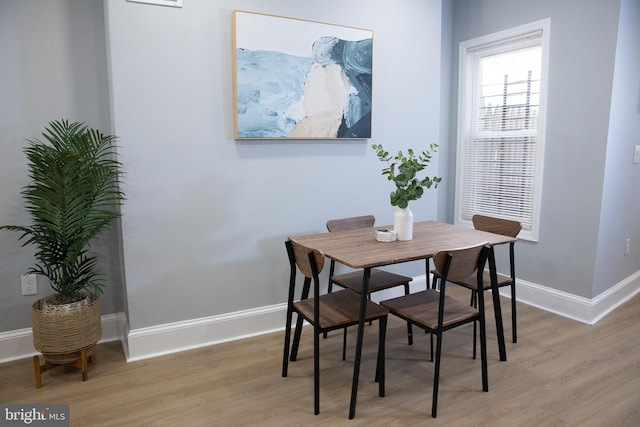 dining space featuring wood finished floors and baseboards