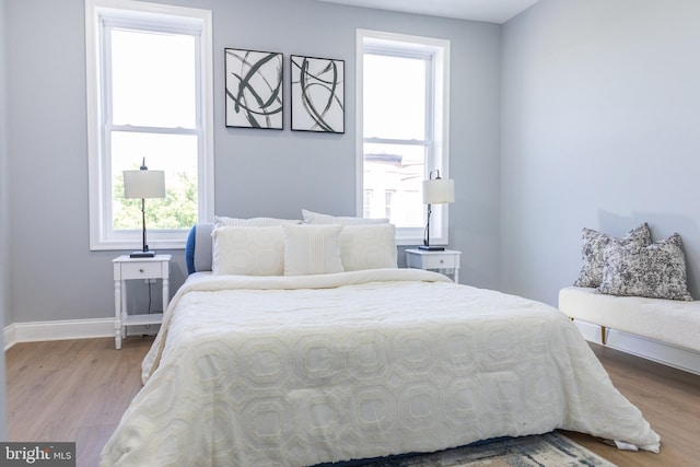 bedroom with wood finished floors and baseboards
