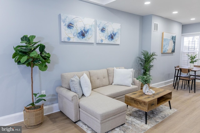 living area featuring light wood finished floors, baseboards, and recessed lighting