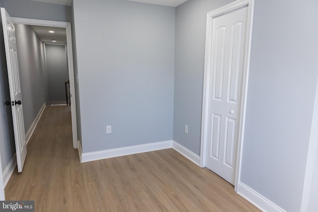 unfurnished bedroom with light wood-type flooring and baseboards