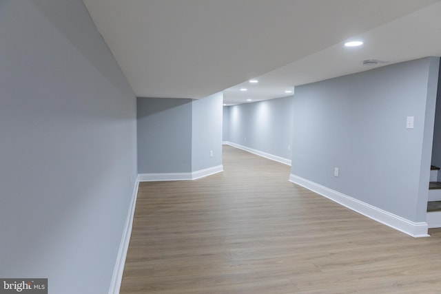 finished below grade area featuring baseboards, recessed lighting, and wood finished floors