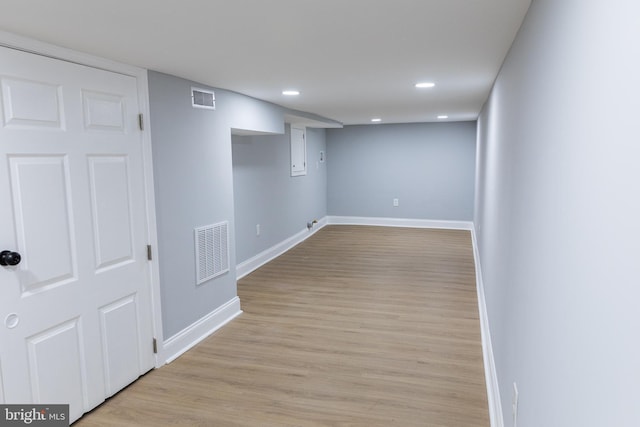 finished below grade area with baseboards, recessed lighting, and light wood-style flooring