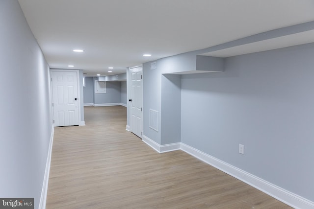 finished basement featuring baseboards, light wood finished floors, and recessed lighting