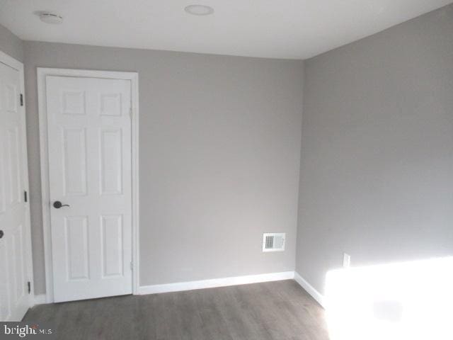 spare room with wood finished floors and baseboards