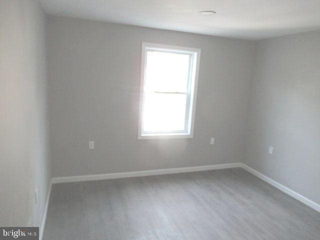 empty room with wood finished floors and baseboards