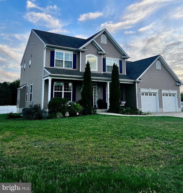 traditional-style house featuring a front yard, a garage, driveway, and a porch