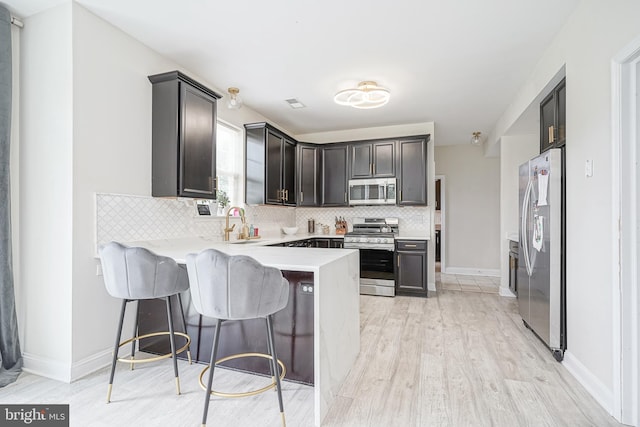 1094 Chews Landing Rd, Laurel Springs, NJ 08021 - kitchen with appliances with stainless steel finishes, a peninsula, backsplash, light countertops, and light wood-style floors