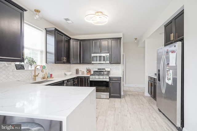 1094 Chews Landing Rd, Laurel Springs, NJ 08021 - kitchen featuring appliances with stainless steel finishes, a sink, light stone countertops, tasteful backsplash, and light wood-style flooring