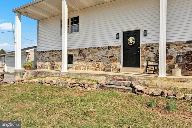913 Pine Grove Rd, Fredericksburg, PA 17026 - doorway to property featuring stone siding, a garage, and a lawn