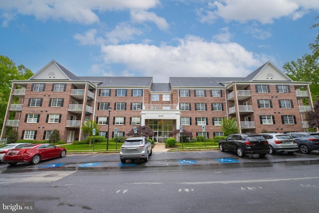 view of apartment building / complex featuring uncovered parking