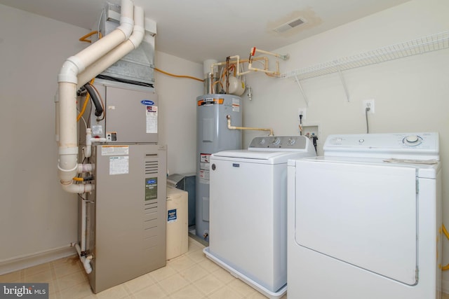 washroom with water heater, separate washer and dryer, and light floors