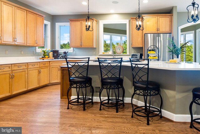 20550 Wildbrook Ct, Ashburn, VA 20147 - kitchen featuring freestanding refrigerator, a breakfast bar, plenty of natural light, recessed lighting, and hanging light fixtures