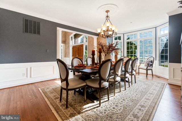 20550 Wildbrook Ct, Ashburn, VA 20147 - dining room with a chandelier, healthy amount of natural light, wood finished floors, a wainscoted wall, and a decorative wall