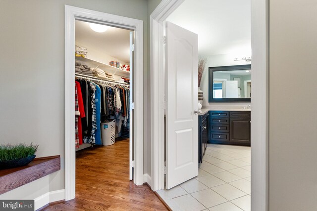 20550 Wildbrook Ct, Ashburn, VA 20147 - hallway featuring light wood-type flooring, a sink, and baseboards