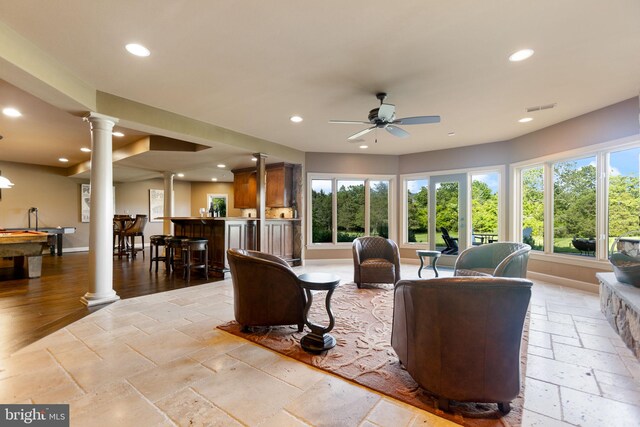 20550 Wildbrook Ct, Ashburn, VA 20147 - living room with ornate columns, stone tile flooring, recessed lighting, a ceiling fan, and bar area