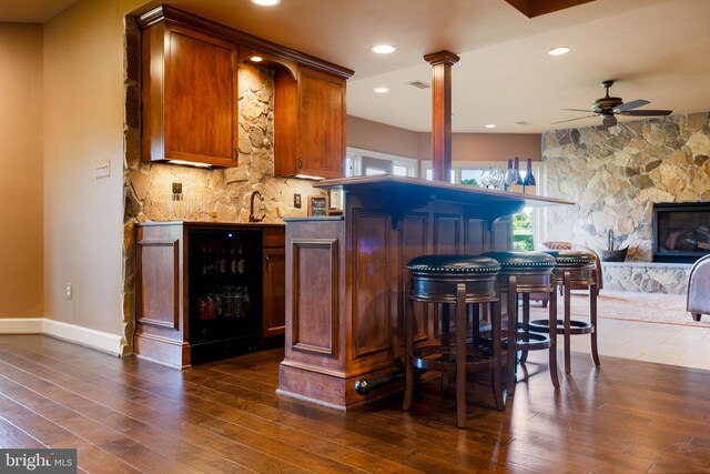 20550 Wildbrook Ct, Ashburn, VA 20147 - indoor dry bar with wine cooler, dark wood-style flooring, a ceiling fan, baseboards, and ornate columns