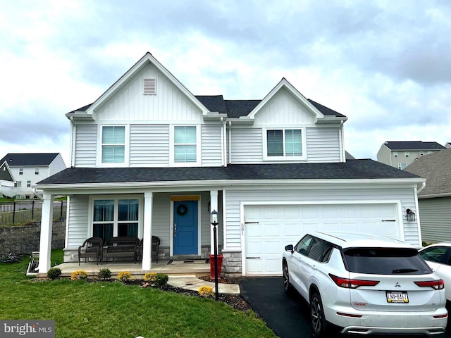view of front of property featuring covered porch, board and batten siding, asphalt driveway, and a shingled roof