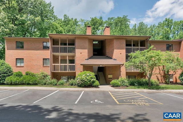 view of property featuring stairs and uncovered parking
