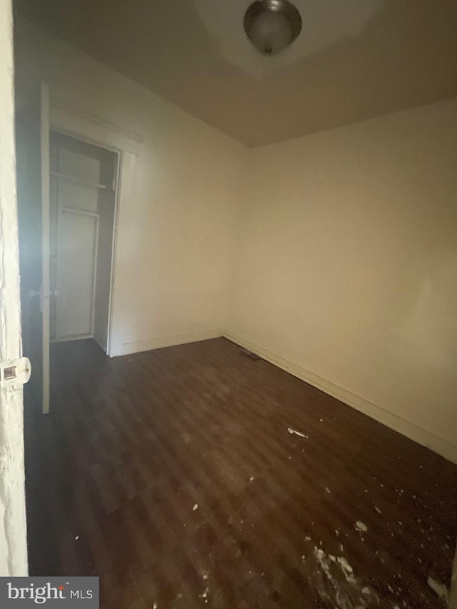 spare room featuring wood finished floors and baseboards