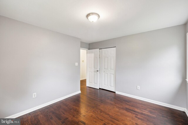 12991 Orleans St, Woodbridge, VA 22192 - unfurnished bedroom with baseboards, dark wood finished floors, and a closet