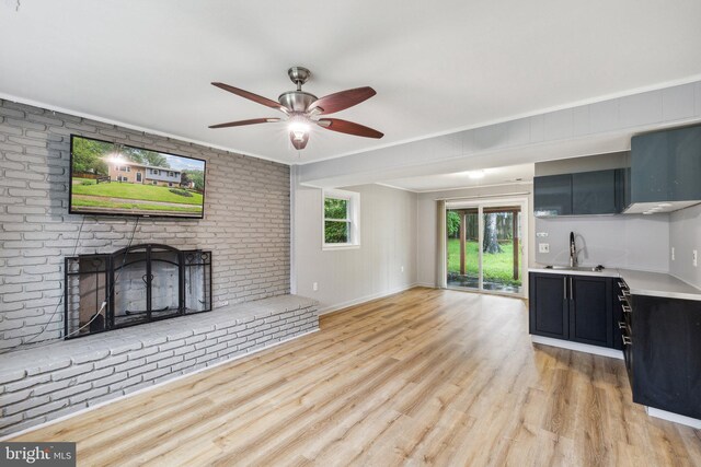 12991 Orleans St, Woodbridge, VA 22192 - unfurnished living room with a sink, light wood-style flooring, a fireplace, a ceiling fan, and crown molding