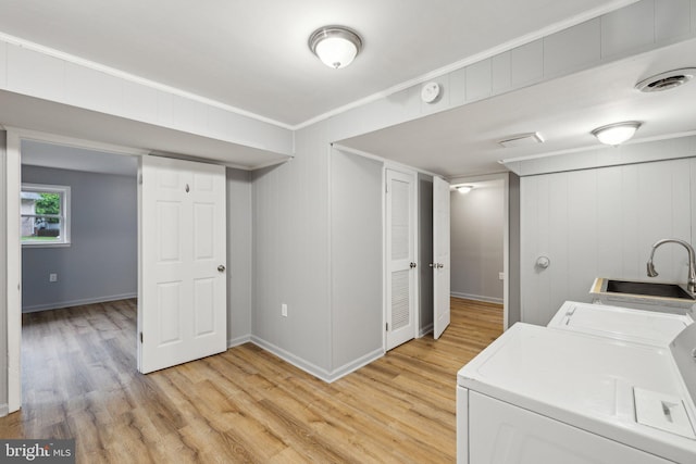 12991 Orleans St, Woodbridge, VA 22192 - laundry room with washer and dryer, light wood-style floors, crown molding, and baseboards
