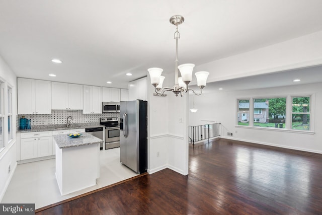 12991 Orleans St, Woodbridge, VA 22192 - kitchen featuring appliances with stainless steel finishes, a sink, backsplash, a chandelier, and light wood-style flooring