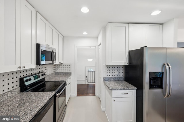 12991 Orleans St, Woodbridge, VA 22192 - kitchen featuring appliances with stainless steel finishes, white cabinetry, decorative backsplash, dark stone counters, and recessed lighting