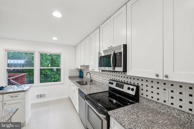 12991 Orleans St, Woodbridge, VA 22192 - kitchen featuring appliances with stainless steel finishes, a sink, white cabinets, light stone counters, and recessed lighting