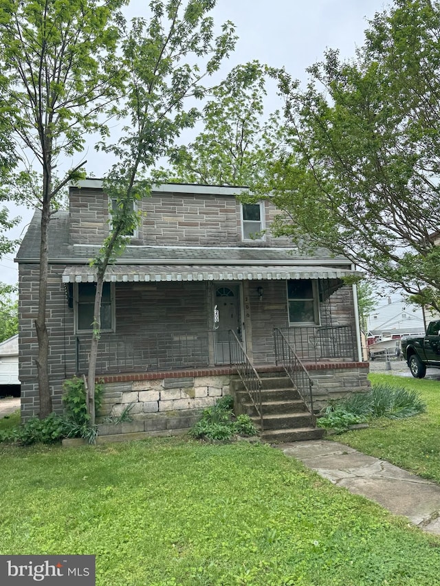 view of front of house featuring a front lawn, a porch, and stone siding