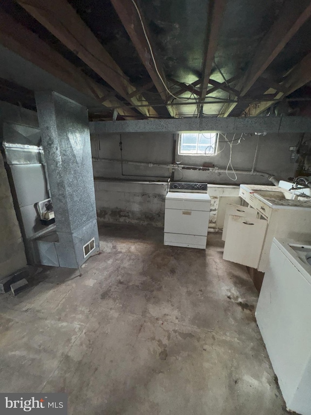 below grade area featuring washer / dryer and heating unit