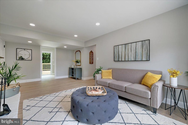 living area featuring light wood finished floors, baseboards, and recessed lighting