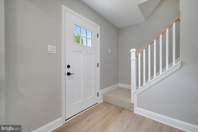 foyer with wood finished floors, stairs, and baseboards