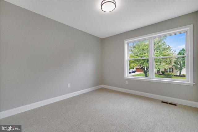 spare room featuring baseboards and light carpet