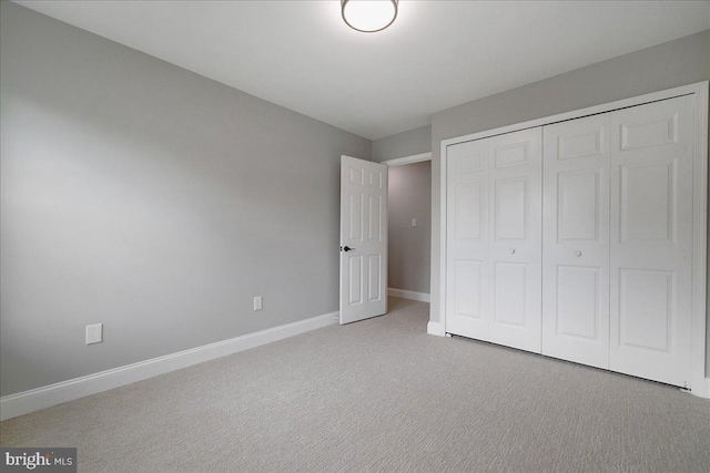unfurnished bedroom with carpet, baseboards, and a closet