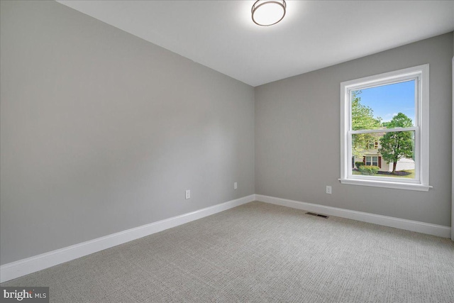 unfurnished room with baseboards and light carpet