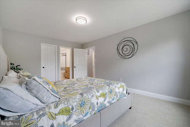 carpeted bedroom with baseboards and connected bathroom