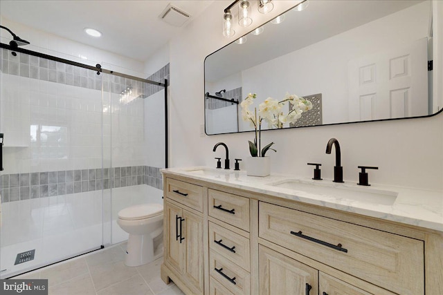 bathroom with a stall shower, toilet, double vanity, and tile patterned flooring