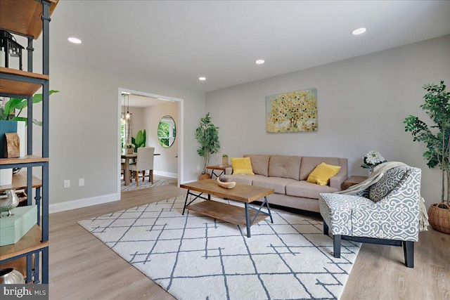 living area featuring light wood-style floors, baseboards, and recessed lighting
