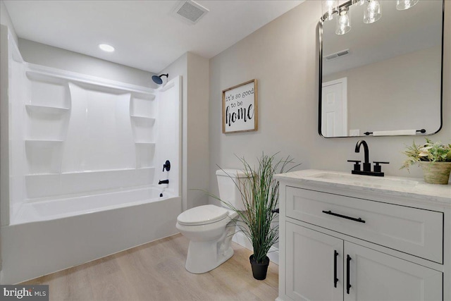 full bathroom with wood finished floors, toilet, vanity, and tub / shower combination