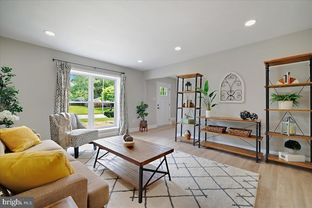 living room featuring light wood-style flooring, recessed lighting, and baseboards