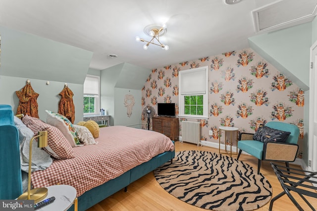 119 Burke, Towson, MD 21286 - bedroom featuring radiator heating unit, multiple windows, wallpapered walls, wood finished floors, and lofted ceiling